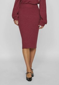 Fustă ribbed, de lungime medie, burgundy, dintr-un material tricotat, cu un talie ajustată. Purtați-o cu tocuri negre lucioase, care au curele la gleznă.