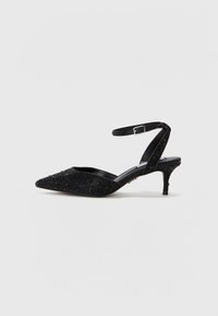 Escarpins noirs à bout pointu avec une tige texturée ornée d'accents étincelants. Une lanière ajustable à la cheville soutient un talon conique fin.