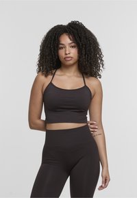 Rudas, prigludęs, trumpas marškinėlis su plonomis petnešėlėmis ir apvaliu iškirpimu, derinamas su aukštai padėtomis, derančiomis legging'ais, pagamintais iš tamprios medžiagos.