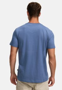 Blauses Baumwoll-T-Shirt mit kurzen Ärmeln, Rundhalsausschnitt und entspannter Passform. Glatte Textur mit einem schlichten Design und ohne sichtbare Logos.