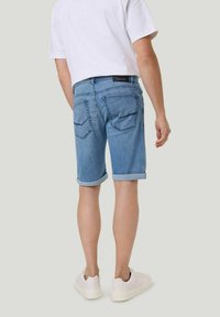 Shorts en denim bleu clair, retroussés en bas, dotés de deux poches arrière avec des coutures contrastées et d'une étiquette à la taille.