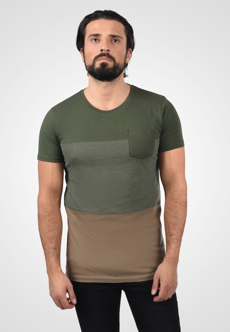 Kortærmet t-shirt med grønne og beige farveblokke, struktureret stof og en brystlomme. Glat bomuldsblanding, rund halsudskæring.