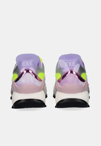 Un par de zapatillas coloridas con acentos en púrpura, amarillo neón y rosa metálico, mostrando la vista trasera con la marca "EXÉ" en la etiqueta del talón.