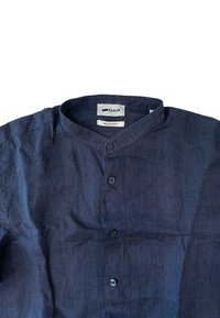 Camicia in lino blu navy con colletto alla mandarino, vestibilità regolare. Presenta una pattina con bottoni sul davanti e un tessuto texturizzato. Etichetta del marchio visibile all'interno.