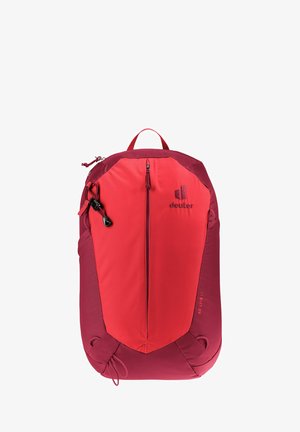 Mochila roja con un diseño aerodinámico, que incluye un bolsillo frontal con cremallera, correas ajustables y tejido texturizado. Logotipo de la marca visible.
