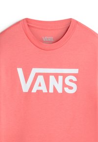 Korallrosa t-shirt med rund halsringning och korta ärmar. Har en stor vit "VANS"-logotyp över bröstet. Mjuk tygkänsla.