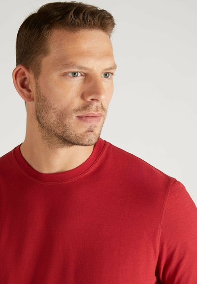 T-shirt in cotone rosso con scollo rotondo, maniche corte e una texture liscia. Presenta cuciture piatte e un design aderente.