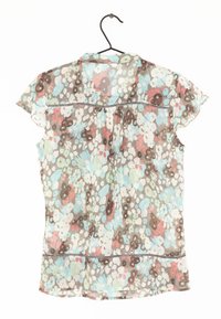 Korte mouwen bloemenblouse in lichte stof. Het patroon bevat blauwe, groene, rode en bruine bloemen met een iets gerimpelde zoom en kraag.