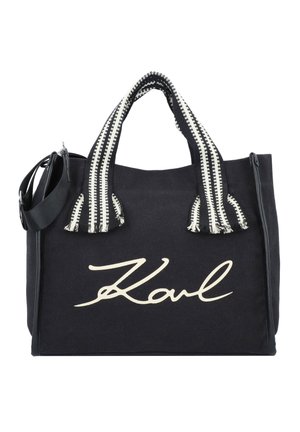 Musta kangaskassi, jossa valkoiset raidalliset kahvat ja edessä suuri kermaisen värinen "Karl"-teksti.