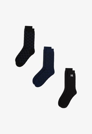 Tri parova posadnih čarapa u crnoj i mornarsko plavoj boji s suptilnim geometrijskim uzorcima, prikazano na bijeloj pozadini.