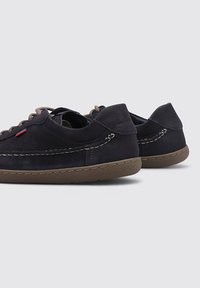 Zapatos de cuero azul marino con acentos marrones, que presentan una superficie texturizada, punta redondeada y costuras en contraste para un detalle adicional.