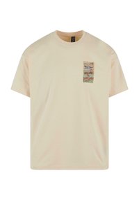 T-shirt kratkih rukava svijetle bež boje izrađen od pamuka. Sadrži tiskani grafički dizajn džepa s tekstom u raznim bojama. Okrugli izrez.
