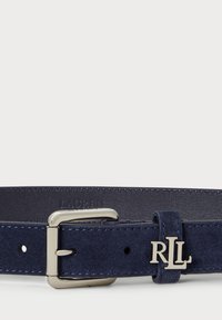 Morske modra semiš pas z zlatim kovinskim sponko in poudarjenim logotipom RLL, gladke teksture in vidnimi luknjami za prilagajanje.