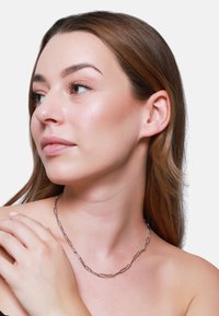 Collana in argento con forme allungate collegate. Texture liscia con una finitura lucida, che si adagia elegantemente attorno al collo.