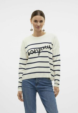 Wit gestreept sweater met marineblauwe lijnen, met het woord "bonjour" in dikke zwarte stiksels. Gecombineerd met blauwe jeans.