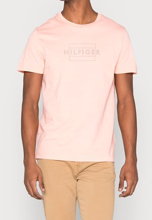 Tričko s krátkým rukávem a kulatým výstřihem v světle růžové bavlně s tónovaným potiskem loga "HILFIGER" na hrudi. Hladká textura, běžný střih.
