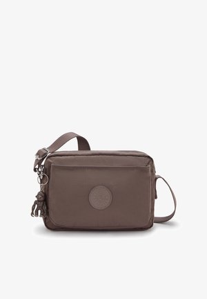 Mała prostokątna brązowa torebka na ramię z przednią kieszenią, regulowanym paskiem, okrągłą naszywką z logo oraz dołączonym brelokiem w kształcie małpy.