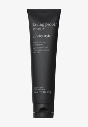 Zwarte knijpbuis van Living Proof air-dry styler, 148 ml. Heeft witte tekst en een ronde dop. Het etiket vermeldt "stylingcrème" in het Engels en het Frans.