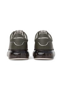 Sneaker in pelle verde con suola trasparente nera; presenta un dettaglio del logo sul tallone e un design liscio e aerodinamico.