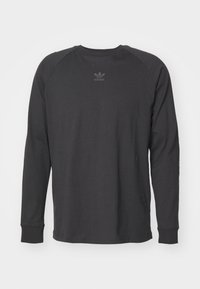 Black long-sleeve shirt made of cotton with a crew neck, raglan sleeves, and a small tonal Adidas logo on the chest.
