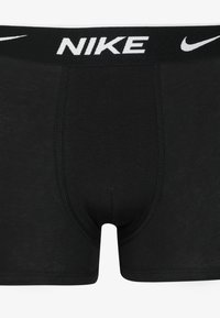 Black Nike boxer shorts featuring a wide elastic waistband with white logo, smooth fabric, and a fitted design with lining detail.