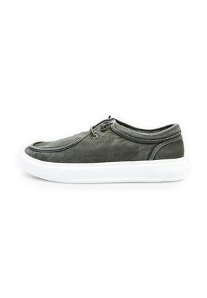 Dark green canvas sneaker with a rounded toe, white rubber sole, and minimal lacing. Features stitched accents around the collar.