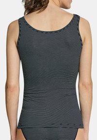 Canottiera a righe bianche e nere con scollatura a girocollo e design aderente, caratterizzata da una texture liscia e leggermente svasata all'orlo.