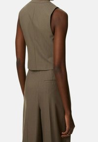 Brązowy top bez rękawów w prążki, o dopasowanym kroju, z wysokim dekoltem i taliowanym tyłem. Tkanina wydaje się gładka i usztywniona.