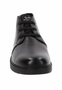 Zwarte leren schoen met een gladde afwerking, ronde neus en verhoogde zwarte veters. Beschikt over een robuuste zwarte rubberen zool en een merkgebonden tong.