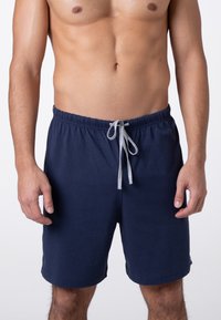 Pantaloni corti in cotone blu navy con fascia elasticizzata in vita e cordino grigio chiaro. Presentano tasche laterali e una linea dritta. Texture morbida.