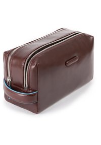 Bolsa de aseo de cuero marrón con doble cremallera, forma rectangular y un detalle azul en el asa para un transporte fácil.