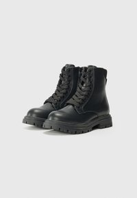 Botines de cuero negro con cordones en la parte delantera, cremallera en el lateral, suela resistente, punta redondeada y costuras reforzadas para mayor durabilidad.