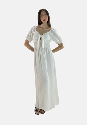 Vestido maxi blanco con mangas abullonadas y un detalle de lazo en el frente. Presenta una cintura fruncida y una tela ligera, que proporciona una silueta fluida.