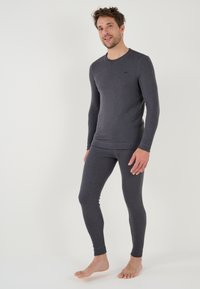 Set di biancheria termica grigia, realizzato in tessuto elastico. Maglietta a maniche lunghe con collo stondato e leggings abbinati attillati. Texture liscia.