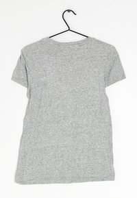 Šedé tričko s krátkým rukávem vyrobené z jersey materiálu. Obsahuje kulatý výstřih a volný střih, vystavené na černém ramínku.