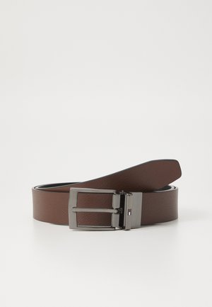 Ceinture en cuir marron avec une finition texturée, dotée d'une boucle rectangulaire en argent et d'un petit logo coloré sur le côté de la boucle.