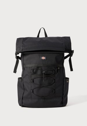 Schwarzer Rucksack mit umklappbarem Deckel, verstellbaren Trägern, elastischen Kordeldetails, Seitentaschen und einem Logo-Patch auf der Vorderseite. Robuste Stoffkonstruktion.