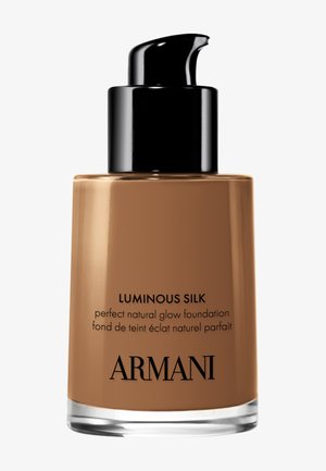 Pompflesje van Armani Luminous Silk foundation voor een perfecte natuurlijke gloed in medium bruine tint op een witte achtergrond.