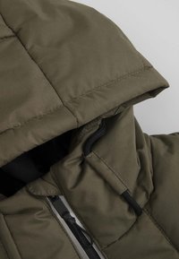 Oliwkowa kurtka puchowa z kapturem, z zapięciem na zamek błyskawiczny i czarnym uchwytem, wykonana z gładkiego, trwałego materiału w pikowanym wzorze.