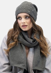Gray knitted beanie with decorative pearls and a matching textured scarf. Both have a soft, cozy appearance and a seamless design.