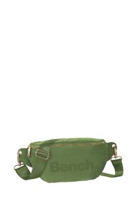 Groene stoffen schoudertas met ritssluiting, verstelbare strap en gouden hardware. Heeft een opvallend gedrukt logo aan de voorkant.