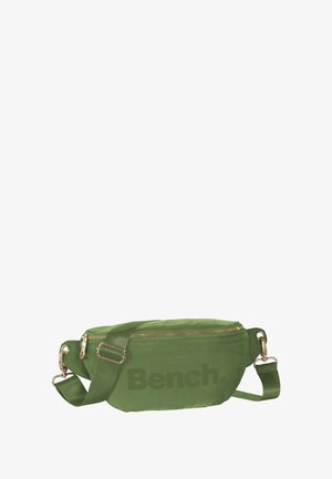 Sac bandoulière en tissu vert avec fermeture éclair, bandoulière ajustable et quincaillerie dorée. Présente un logo imprimé prominent à l'avant.