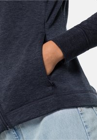 Felpa blu navy con tasca laterale con chiusura a zip, realizzata in morbido tessuto testurizzato e rifinita con maniche a costina.