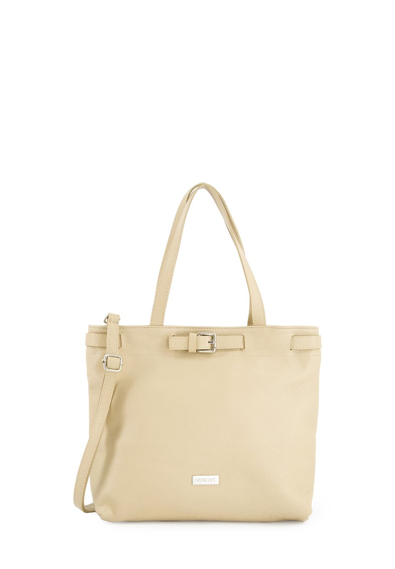Beige læder tote bag med to skulderremme, en aftagelig crossbody-rem og en spændeaccent foran. Glat tekstur, minimalistisk design.