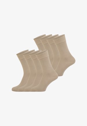 Acht Paare beige knöchellange Socken mit gerippten Bündchen, in zwei überlappenden Reihen vor weißem Hintergrund angeordnet.