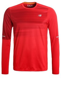 T-shirt de sport à manches longues rouge en tissu léger. Il présente un col rond, des accents réfléchissants et un logo en haut à gauche.