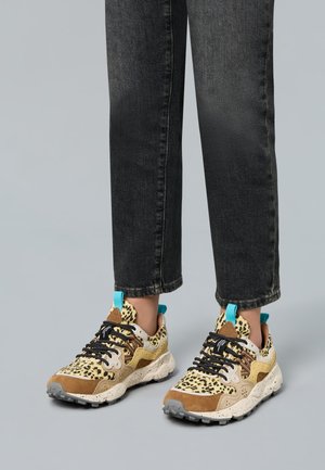 Leopard print sneakers with beige, brown, and turquoise accents; textured materials; thick, speckled sole; black laces.