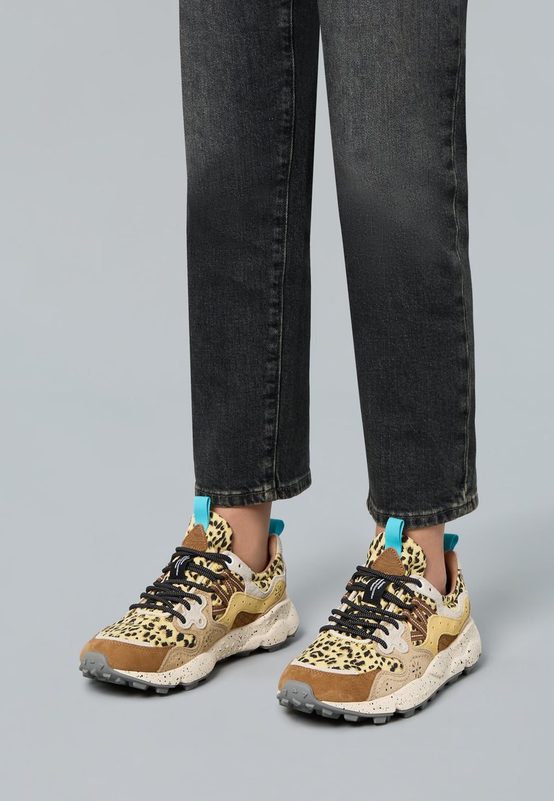 Sneaker con stampa leopardata con accenti beige, marroni e turchesi; materiali texturizzati; suola spessa e maculata; lacci neri.