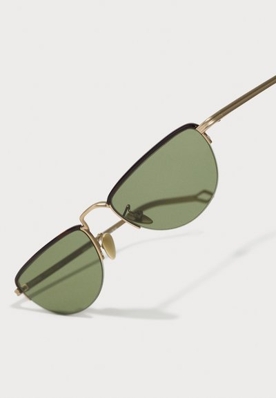 Green-tinted, triangular sunglasses with gold metal accents, featuring a unique double brow bridge and nose pads for comfort.