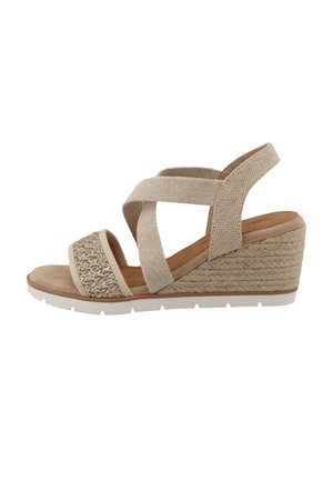 Sandale compensée beige avec des brides croisées en tissu, une texture tissée sur la zone des orteils et un talon compensé de style espadrille texturé.